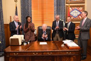 Gov. Hutchinson, center, celebrates after signing the bill.